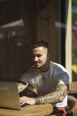 Elinde dizüstü bilgisayar olan genç bir adam.