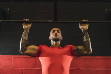 Spor salonunda kırmızı zille egzersiz yapan genç bir sporcu. Crossfit erkek fitness eğitimi.