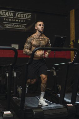 Spor salonunda halterli adam eğitimi.