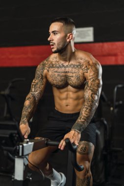 Genç adam ağırlık egzersizi yapıyor.