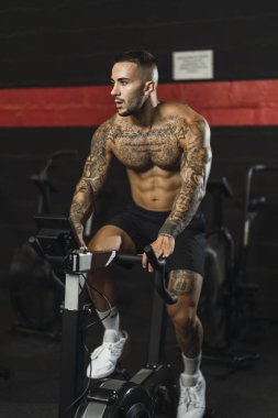 Kaslı adam dumbbell ile egzersiz yaparak