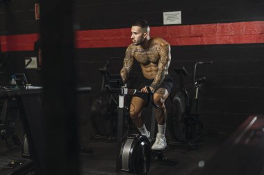 yakışıklı genç kaslı adam halterle egzersiz yapıyor.