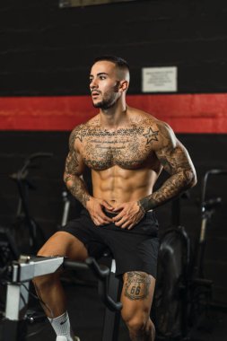 Spor kıyafetli genç kaslı adam spor salonunda egzersiz yapıyor..