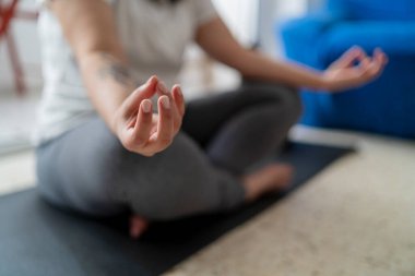 Kadın evde meditasyon yapıyor, yakın plan.