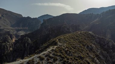 Bulutlu ve mavi gökyüzü olan dağ manzarası.