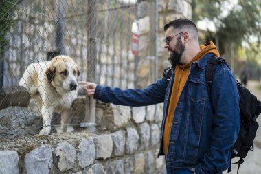 Köpekli bir adam parkta sahibiyle yürüyor.