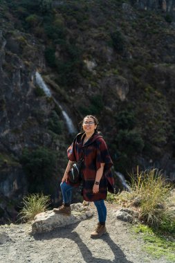 Sırt çantalı genç bir kadın dağda yürüyüş yapıyor.
