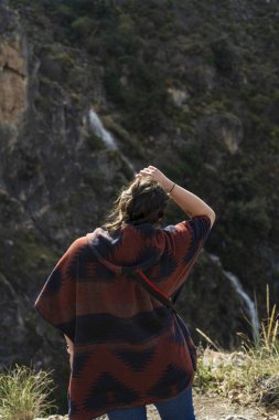 Kumsalda sırt çantalı genç bir kadın.