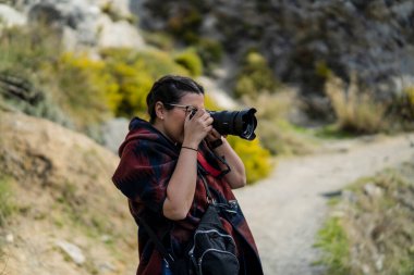 Kadın turist dağlarda fotoğraf çekiyor.