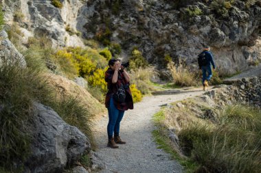 Sırt çantalı iki yürüyüşçü dağlarda yürüyüş yapıyor.