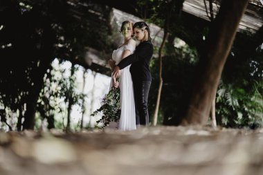 Genç bir çift nehir kenarındaki bir ormanda poz veriyor.