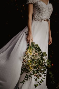 Beyaz elbiseli gelinin elinde bir buket beyaz çiçek vardı.