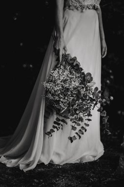 Doğada düğün buketi olan güzel gelin.