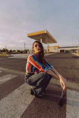 Genç güzel kız otoparkta poz veriyor.