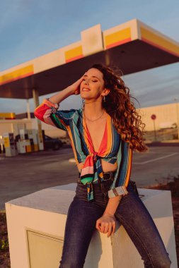 Kızıl saçlı ve mavi gözlü genç kız köprüde poz veriyor.