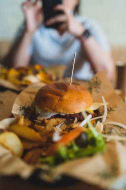 Adam lezzetli burger yiyor.