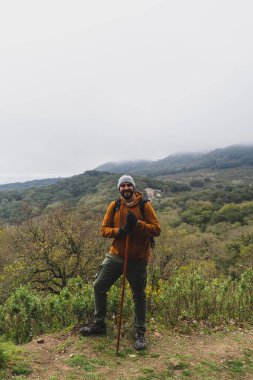 Sırt çantalı erkek yürüyüşçü Tepedeki cep telefonundan selfie çekiyor