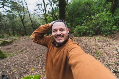 Genç adam ormanda selfie çekiyor..
