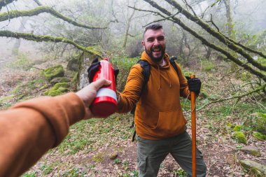 Sırt çantalı bir adam ormanda yürüyüş yapıyor.