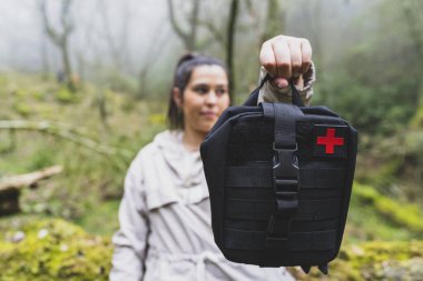 Dışarıda ilkyardım çantası olan üniformalı bir kadın.