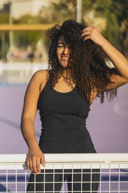 Sahilde poz verirken gülümseyen güzel bir genç kadın.