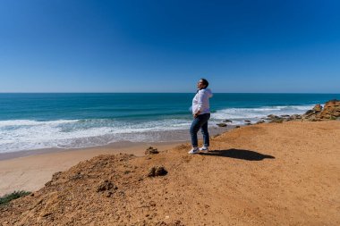 Portekiz 'de kumlu bir sahilde genç bir adam.