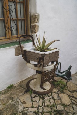 Eski ahşap sandalye ve tencere bir evin terasında.