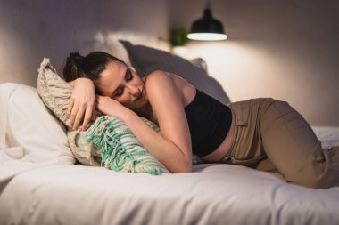Genç kadın yatakta uyuyor.
