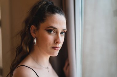 Otelin penceresinde poz veren güzel bir kız.