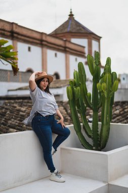 Arkasında kaktüs olan genç bir kadın..