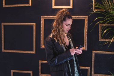 Restoranda cep telefonu kullanan genç bir kadın.