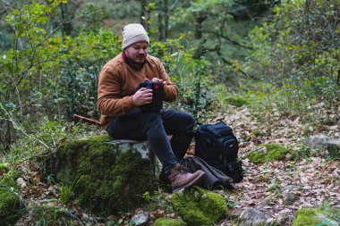 Ormanda sırt çantalı genç, sakallı bir gezgin.