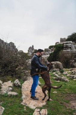 Köpekli bir adam yolda yürüyor.