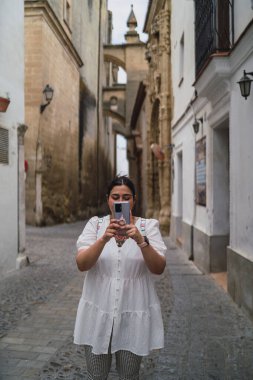 Kameralı genç ve güzel bir kadın eski şehirde fotoğraf çekiyor. yüksek kaliteli fotoğraf