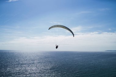 Denizin üzerinde uçan paraglider