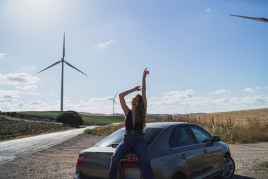 Rüzgâr türbininde mutlu genç bir kadın