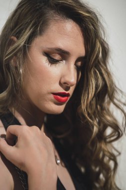 Kırmızı dudaklı ve kıvırcık saçlı güzel bir kız. güzellik ve moda portresi.