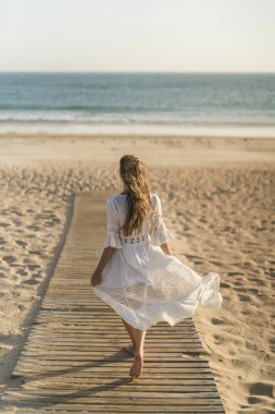 jonge vrouw ontspannen op het strand bij zonsondergang