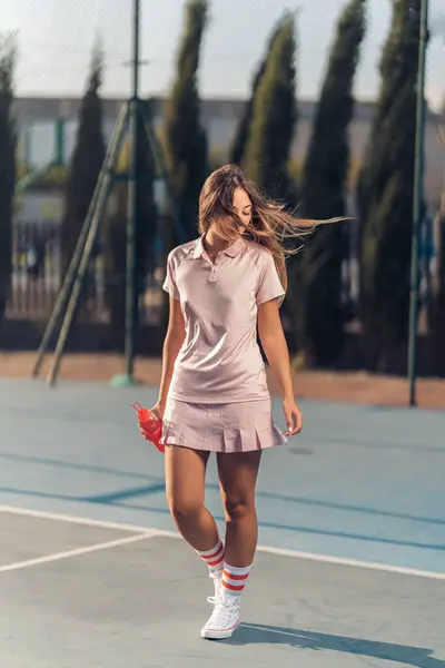 Kırmızı elbiseli kız ve beyaz tişörtlü tenis topu.