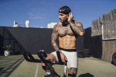 Dövmeli adam vücut egzersizi yapıyor.