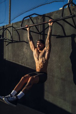 Halterle egzersiz yapan kaslı bir adam..