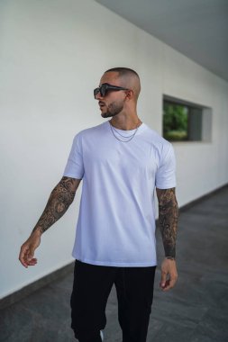 Beyaz gömlekli, sakallı, genç ve yakışıklı bir adam.