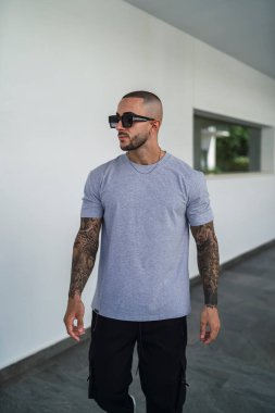 Sokakta duran güneş gözlüklü ve kot pantolonlu şık genç adam..