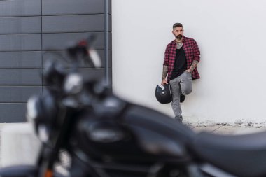 Motosiklette poz veren yakışıklı adam.