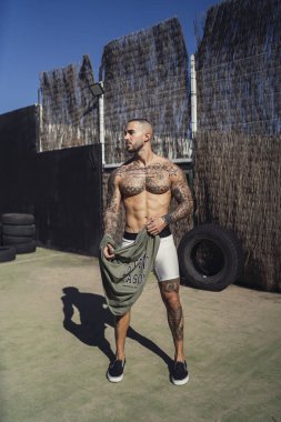 Siyah tişörtlü ve şortlu yakışıklı kaslı adam.