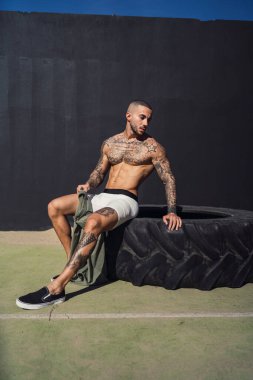 yakışıklı kaslı adam yerde antrenmandan sonra dinleniyor.