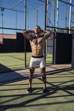 Siyah şortlu ve elinde top olan beyaz tişörtlü genç bir adam..