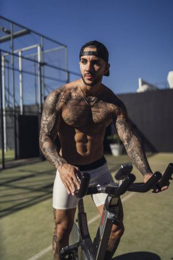 Egzersizleri yapıyor dövmeli genç adam