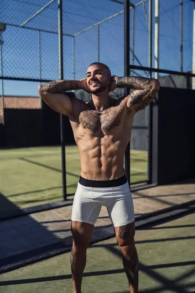 Beyaz tişörtlü ve siyah vücutlu yakışıklı kaslı adam.