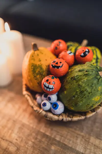 Cadılar bayramı balkabağı, kriko fenerleri ve ahşap masadaki mumlar.